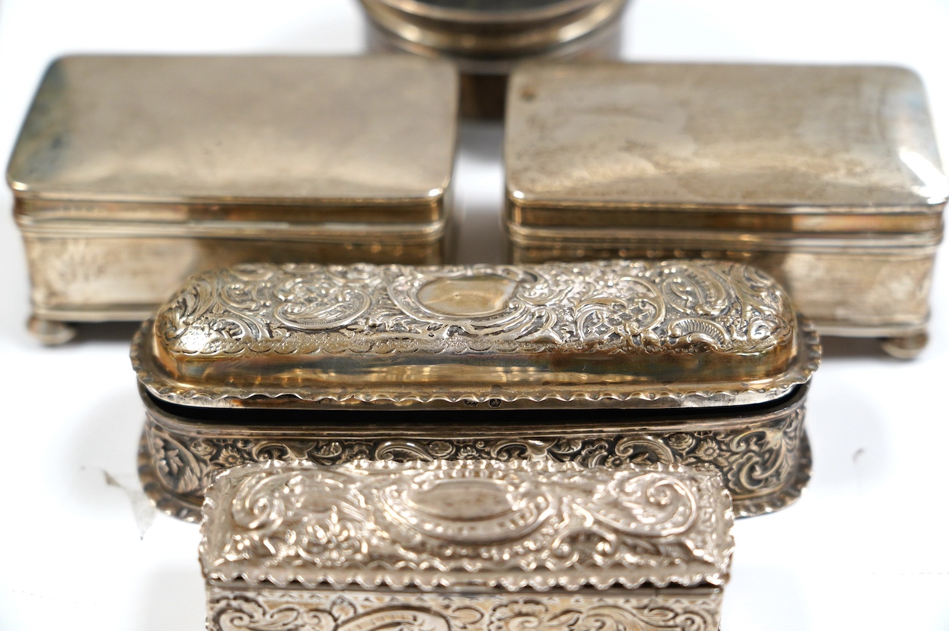 Two late Victorian repousse silver trinket boxes, largest 13.3cm, a pair of George V silver trinket boxes and a tortoiseshell and silver mounted circular trinket box. Condition - poor to fair